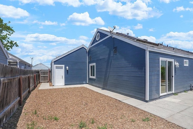 rear view of house with a fenced backyard and a patio area