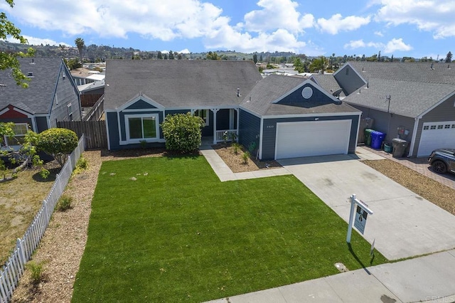 ranch-style home with an attached garage, a front lawn, fence, and driveway