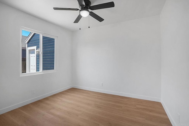 empty room featuring ceiling fan, baseboards, and light wood-style floors