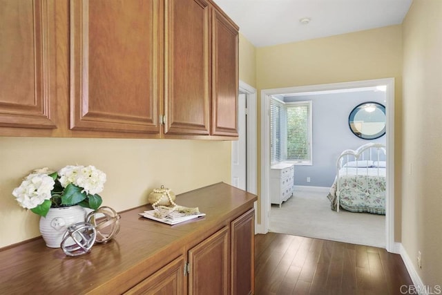 hallway with baseboards and dark wood-style flooring