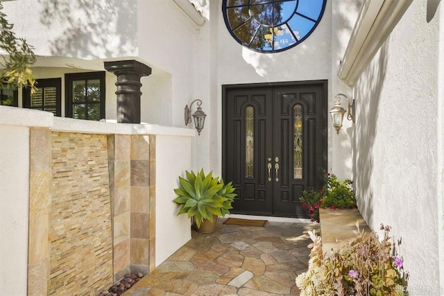 view of exterior entry featuring stucco siding