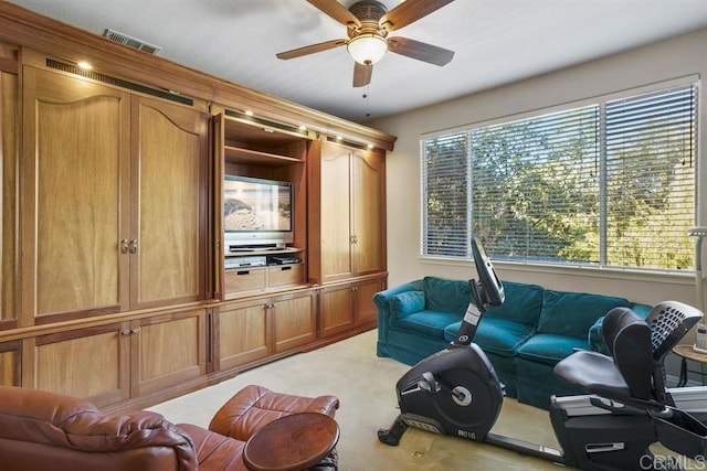 living area featuring visible vents, a ceiling fan, and light carpet
