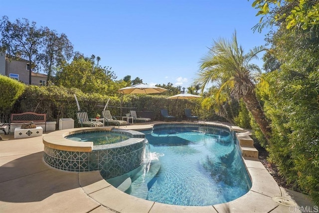 view of swimming pool with a patio, a pool with connected hot tub, and fence