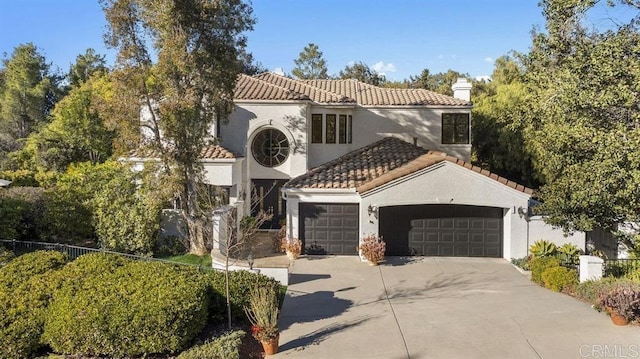 mediterranean / spanish house with an attached garage, stucco siding, a chimney, concrete driveway, and a tiled roof