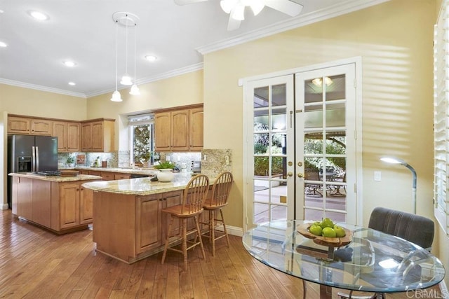 kitchen featuring decorative backsplash, french doors, decorative light fixtures, stainless steel fridge with ice dispenser, and a peninsula