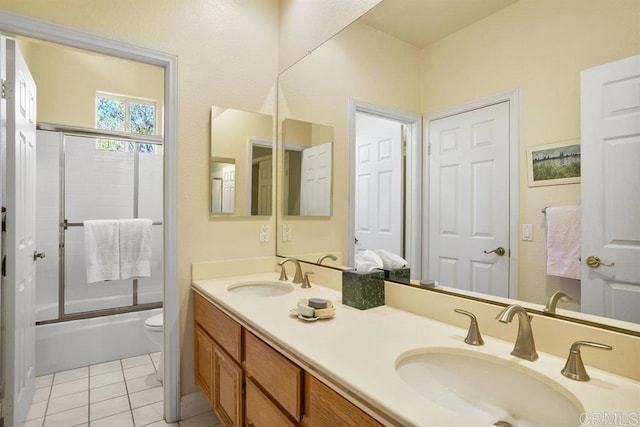 bathroom with tile patterned flooring, a sink, double vanity, and toilet