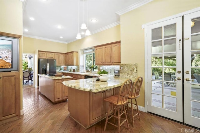 kitchen with decorative backsplash, ornamental molding, and stainless steel refrigerator with ice dispenser