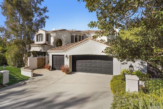 mediterranean / spanish-style home with stucco siding, an attached garage, driveway, and a tiled roof