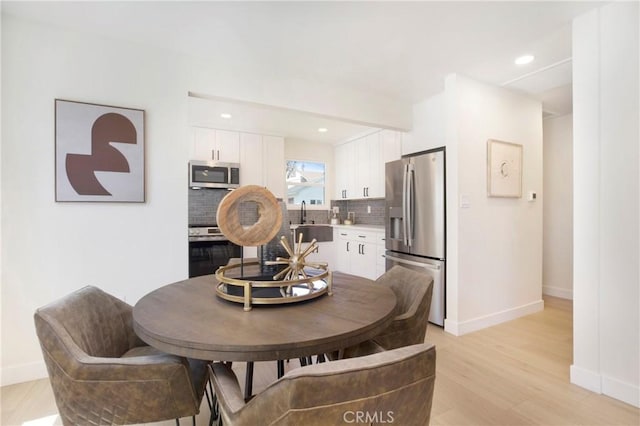dining room featuring baseboards, recessed lighting, and light wood-type flooring
