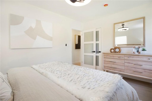 bedroom featuring dark wood-style flooring and french doors