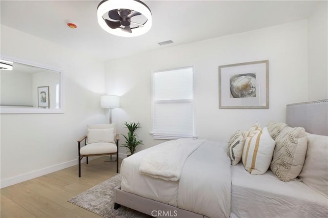 bedroom featuring visible vents, baseboards, and wood finished floors