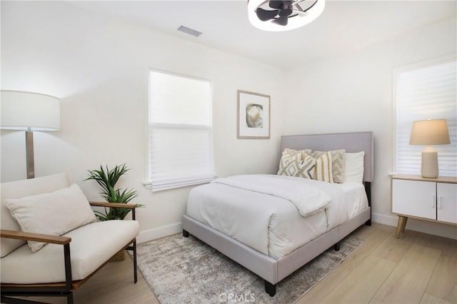 bedroom featuring baseboards, visible vents, and light wood-type flooring