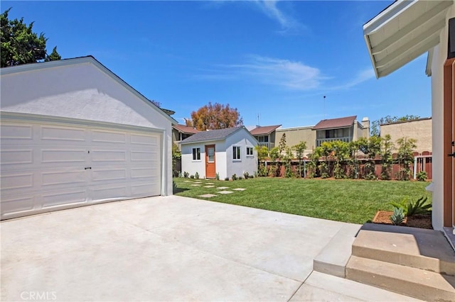 view of yard featuring an outdoor structure, fence, and a detached garage