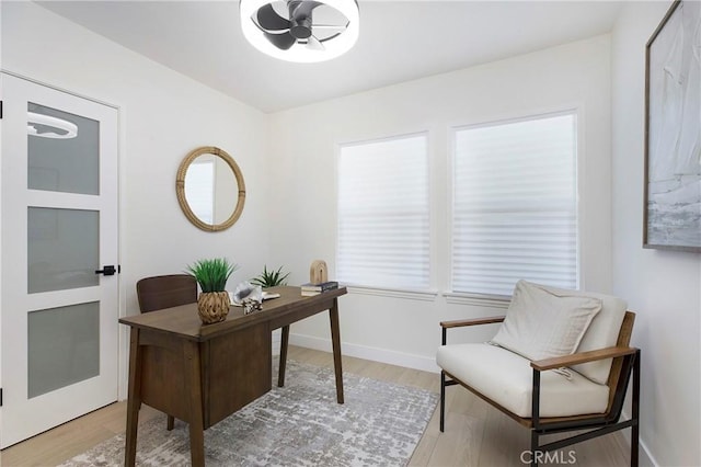 office featuring baseboards, ceiling fan, and light wood finished floors