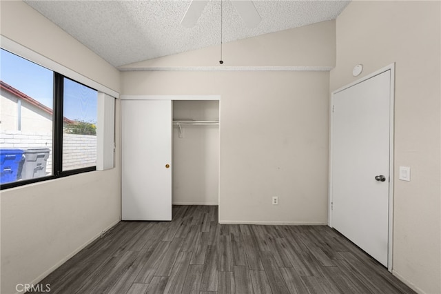 unfurnished bedroom featuring a closet, wood finished floors, lofted ceiling, a textured ceiling, and a ceiling fan