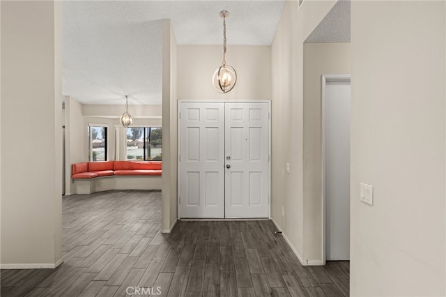 43922 Warner Trl, Palm Desert, CA 92211 - entrance foyer with a chandelier, dark wood finished floors, baseboards, and a textured ceiling