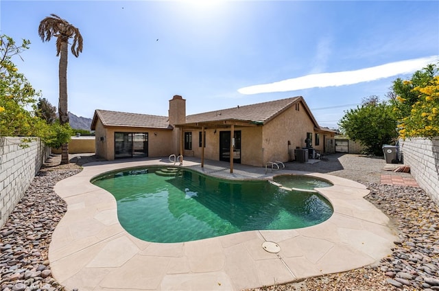 view of swimming pool featuring a patio, a pool with connected hot tub, and a fenced backyard