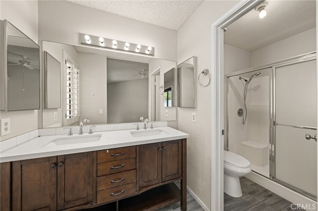 43922 Warner Trl, Palm Desert, CA 92211 - full bathroom featuring ceiling fan, toilet, a shower stall, double vanity, and wood finished floors