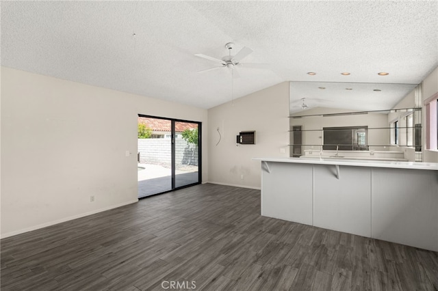 43922 Warner Trl, Palm Desert, CA 92211 - unfurnished living room with a textured ceiling, dark wood-type flooring, lofted ceiling, a ceiling fan, and baseboards