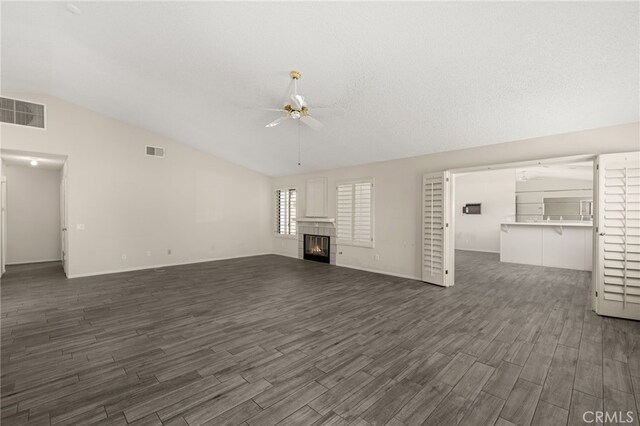43922 Warner Trl, Palm Desert, CA 92211 - unfurnished living room featuring a ceiling fan, vaulted ceiling, dark wood-style floors, a tile fireplace, and baseboards