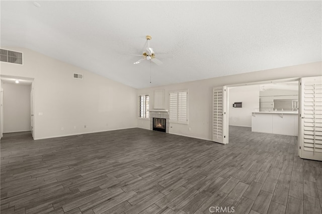 43922 Warner Trl, Palm Desert, CA 92211 - unfurnished living room with ceiling fan, lofted ceiling, dark wood-style flooring, a tile fireplace, and baseboards