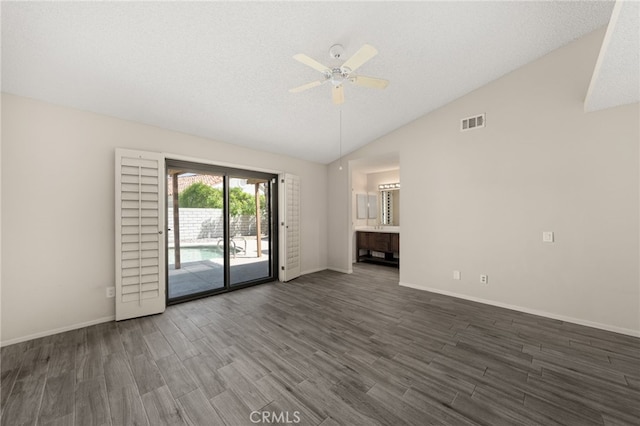 unfurnished living room with visible vents, dark wood-style flooring, baseboards, ceiling fan, and vaulted ceiling