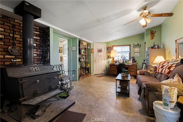 living room featuring ceiling fan and a wood stove