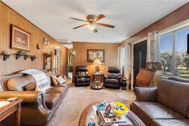 living room featuring ceiling fan, carpet, and wood walls