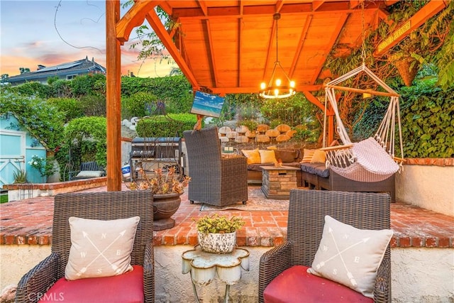 patio terrace at dusk with an outdoor living space with a fire pit