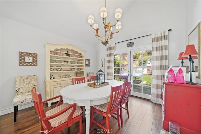 dining room with french doors, lofted ceiling, wood finished floors, and a notable chandelier