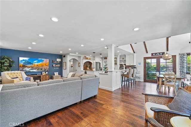 living area with dark wood-style flooring, recessed lighting, and decorative columns