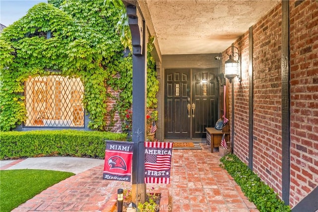 view of exterior entry featuring brick siding