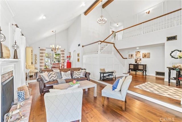living room featuring visible vents, hardwood / wood-style floors, a chandelier, and high vaulted ceiling