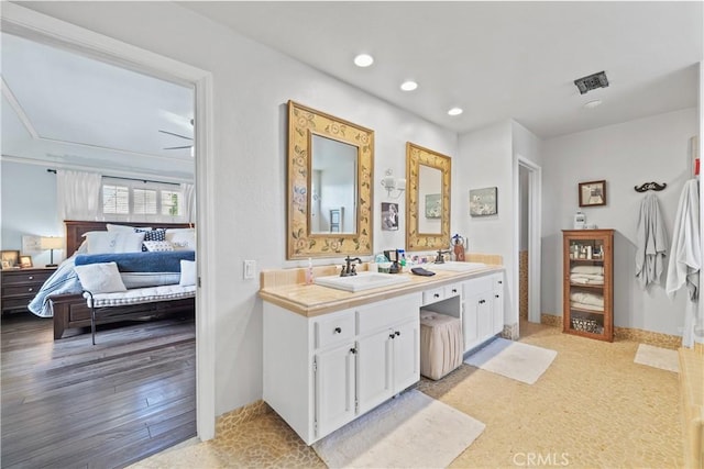 ensuite bathroom with vanity, recessed lighting, baseboards, wood finished floors, and ensuite bathroom