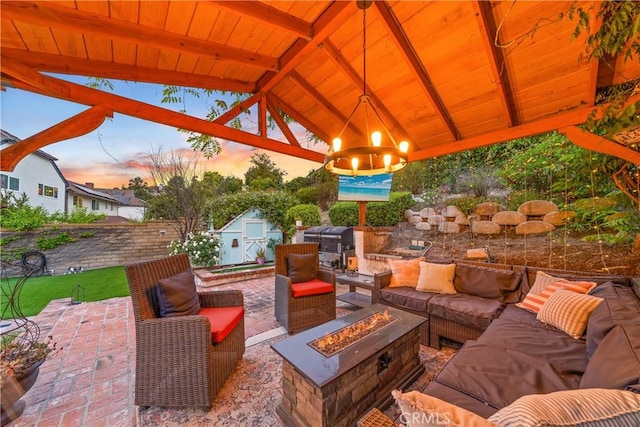 view of patio with a gazebo, an outbuilding, a storage unit, and an outdoor living space with a fire pit