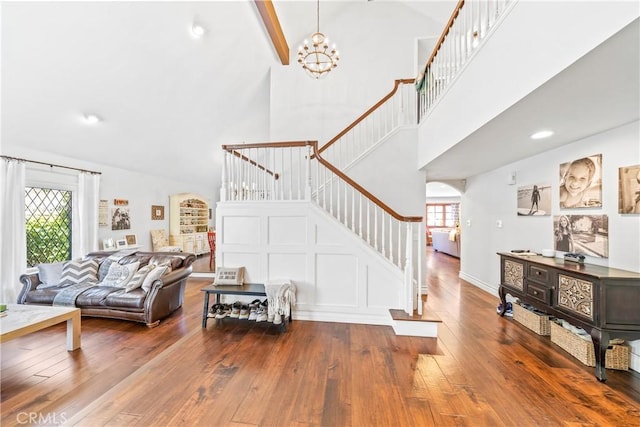 28102 Camellia Ct, Laguna Niguel, CA 92677 - living room featuring a notable chandelier, arched walkways, high vaulted ceiling, stairs, and hardwood / wood-style flooring
