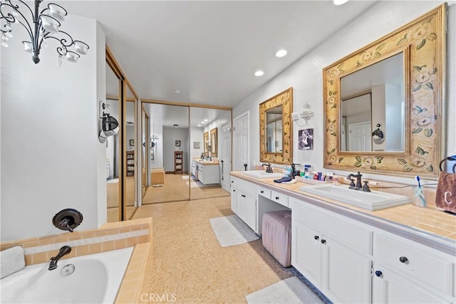 full bath featuring a sink, a washtub, recessed lighting, and double vanity