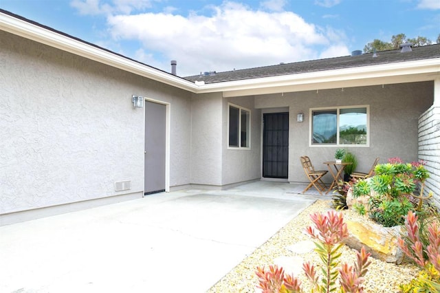 doorway to property with a patio and stucco siding
