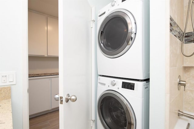 washroom featuring laundry area, light wood-style flooring, and stacked washer / drying machine