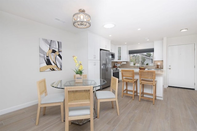 dining area with recessed lighting, baseboards, visible vents, and light wood-style flooring