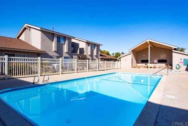 community pool featuring fence and a patio