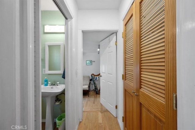 hall with a sink and light wood-type flooring