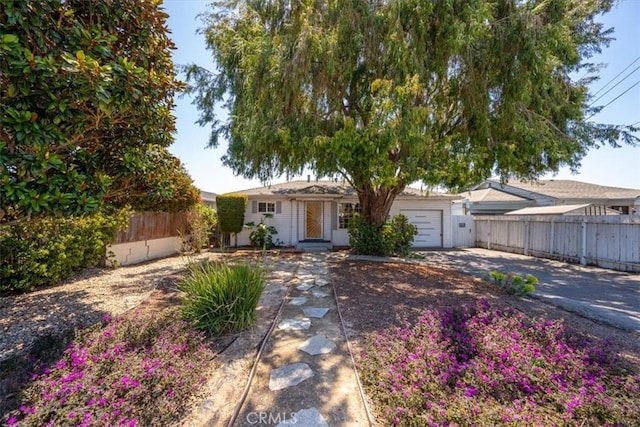 single story home featuring an attached garage, aphalt driveway, and fence