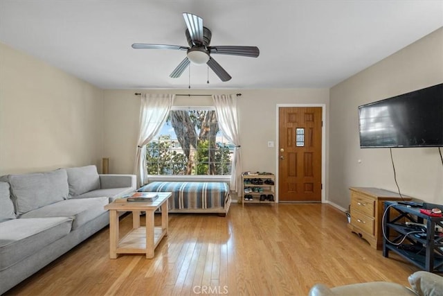 living area with ceiling fan and light wood finished floors