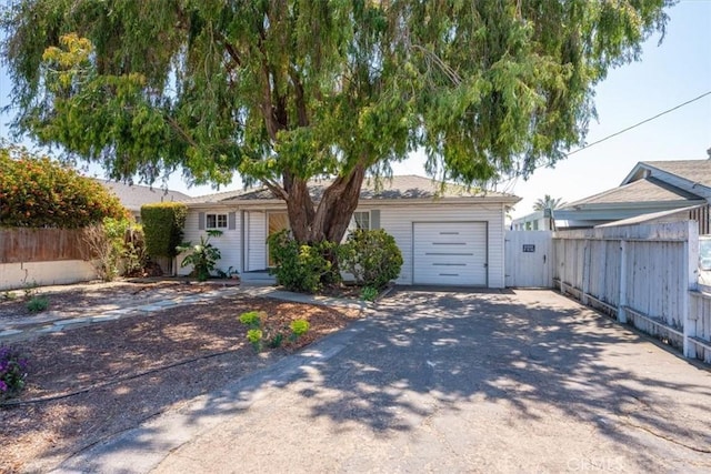 ranch-style house with an attached garage, fence, and concrete driveway