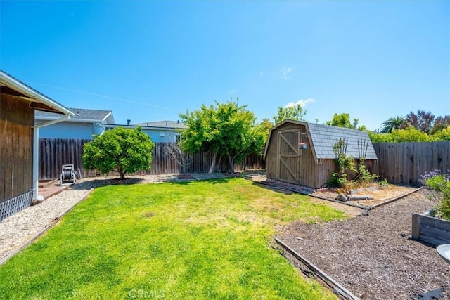 view of yard with an outbuilding, a shed, and a fenced backyard
