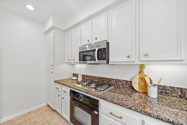 1295 Blue Jean Way Unit 2, Chula Vista, CA 91913 - kitchen featuring appliances with stainless steel finishes, white cabinetry, baseboards, dark stone counters, and light tile patterned flooring