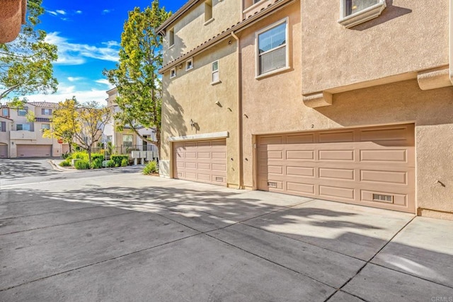 1295 Blue Jean Way Unit 2, Chula Vista, CA 91913 - view of property exterior featuring a garage, stucco siding, concrete driveway, and a residential view