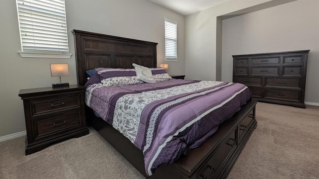 bedroom featuring light colored carpet and baseboards