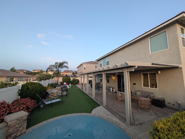 rear view of property featuring stucco siding and a patio area